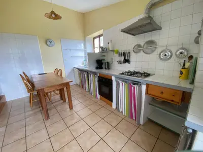 a kitchen with a table and a stove top oven at Gite de Serrelongue in Montségur