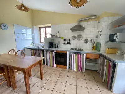 a kitchen with a table and a stove and a table at Gite de Serrelongue in Montségur