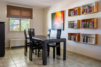 a dining room with a table and chairs and bookshelves at Le Petit Viala in Capestang