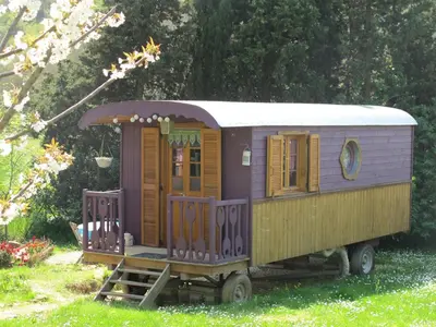 a small train car is sitting in the grass at Les Roulottes Du Lauragais in Montmaur