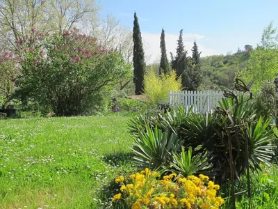 a garden with flowers and a white fence at Les Roulottes Du Lauragais in Montmaur