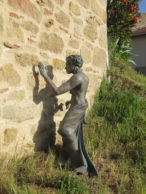 a statue of a woman casting a shadow on a wall at Les Roulottes Du Lauragais in Montmaur