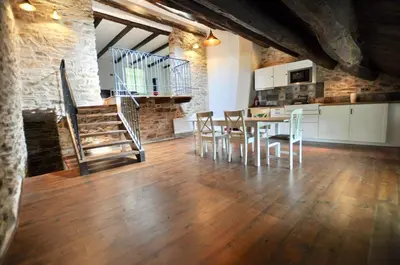a kitchen and dining room with a table and chairs at Les Coumayres in Riols