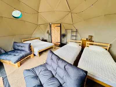 a room with three beds and a couch in a yurt at Les Coumayres in Riols