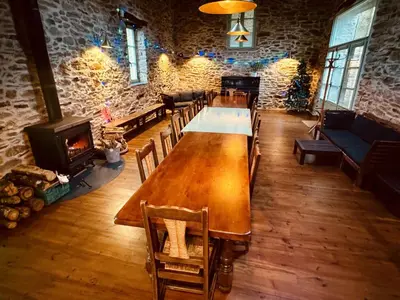 a large wooden table in a room with a fireplace at Les Coumayres in Riols
