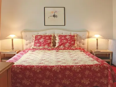 a bedroom with a red bed with two lamps at Château de la Prade in Bram