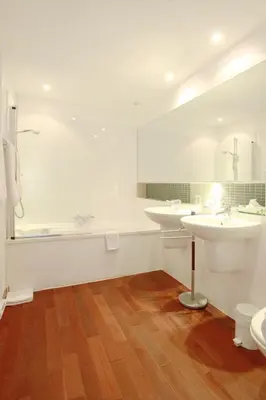 a white bathroom with two sinks and a tub at Château de la Prade in Bram