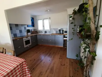 a kitchen with gray cabinets and a wooden floor at Domaine Limouzy in Narbonne