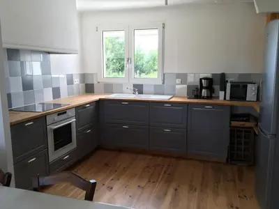 a kitchen with gray cabinets and a wooden floor at Domaine Limouzy in Narbonne