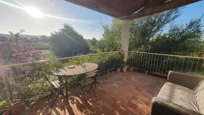 a patio with a table and chairs on a balcony at Domaine Limouzy in Narbonne