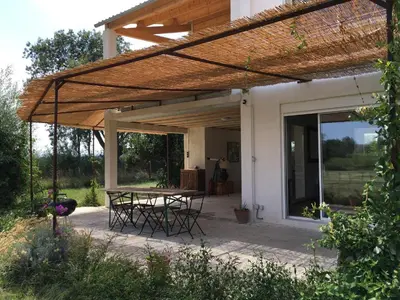 a patio with a table and chairs under a pergola at Domaine Limouzy in Narbonne