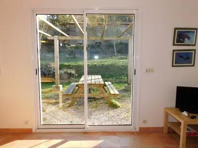 a sliding glass door with a picnic table outside at Bergerie Du Plo in Montlaur