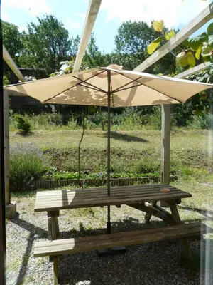 a picnic table with an umbrella in a yard at Bergerie Du Plo in Montlaur