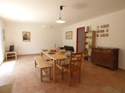 a living room with a wooden table and chairs at Bergerie Du Plo in Montlaur
