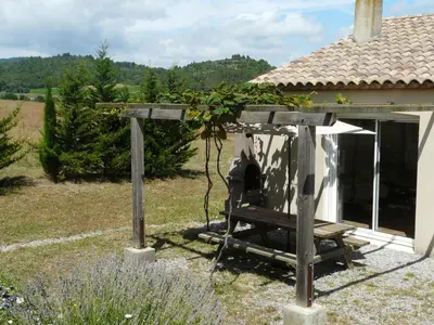 a garden with a bench in front of a house at Bergerie Du Plo in Montlaur