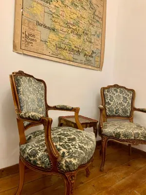 two chairs in a room with a map on the wall at L'Ancienne Boulangerie in Caunes-Minervois