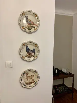 three plates are hanging on a white wall at L'Ancienne Boulangerie in Caunes-Minervois