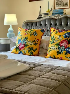 a bed with two colorful pillows on it at L'Ancienne Boulangerie in Caunes-Minervois
