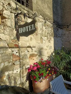a sign on the side of a building with flowers at L'Ancienne Boulangerie in Caunes-Minervois
