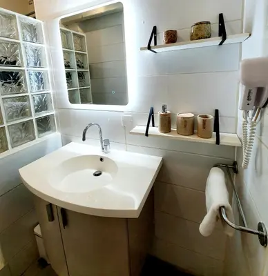 a white bathroom with a sink and a mirror at La Caponnière in Carcassonne