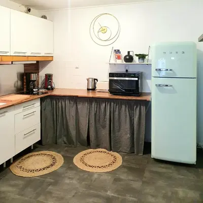 a kitchen with a refrigerator and a counter with mats at La Caponnière in Carcassonne