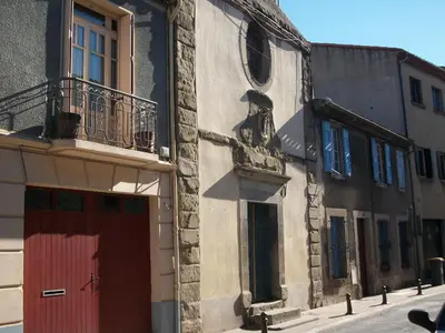 a building with a statue on the side of it at La Caponnière in Carcassonne
