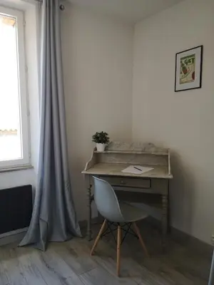 a desk and a chair in a room with a window at Appartement du GET in Revel