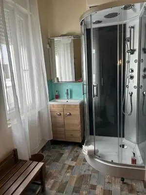 a bathroom with a shower and a sink and a bench at Hotel de France in Narbonne