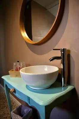 a bathroom sink with a large white bowl on a table with a mirror at Hotel de France in Narbonne