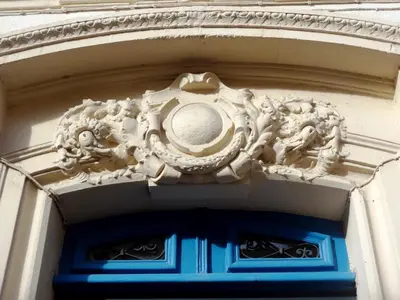 a building with a carving on the side of a door at Hotel de France in Narbonne