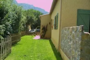 a yard of a house with a fence and green grass at La Claouzo in Duilhac