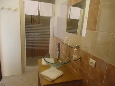 a bathroom with a glass sink and a shower at La Claouzo in Duilhac