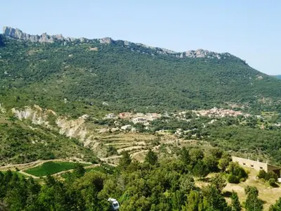 a view of a mountain with trees and houses on it at La Claouzo in Duilhac