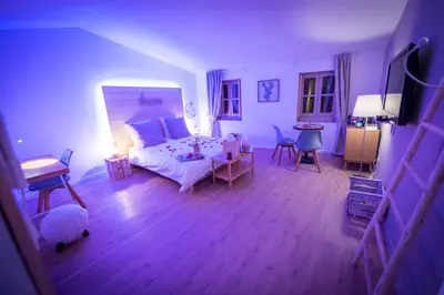 a bedroom with a bed and a table and chairs at La Maison Gustave in Narbonne