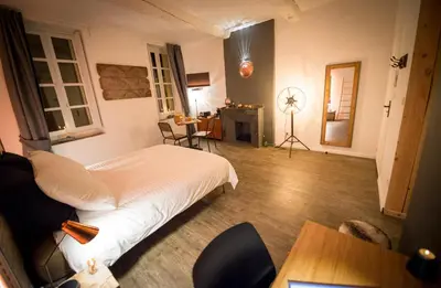 a bedroom with a bed and a desk and a table at La Maison Gustave in Narbonne