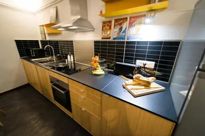 a kitchen with black tiles and a counter top at La Maison Gustave in Narbonne