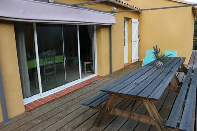 a wooden deck with a wooden picnic table on a house at Etape Cathare in Duilhac