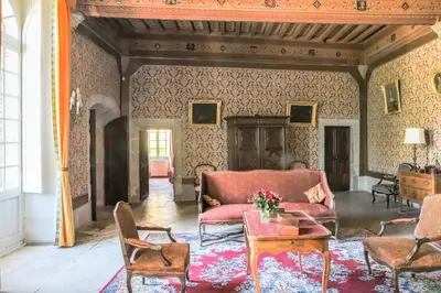 a living room with a red couch and chairs at Château d'Agel gite in Agel