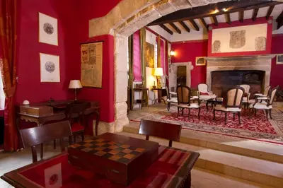a living room with red walls and a fireplace at Château d'Agel gite in Agel