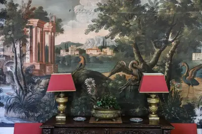 two lamps on a table in front of a mural at Château d'Agel gite in Agel