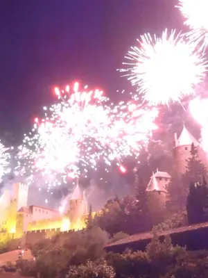 a fireworks display in front of a castle at night at Bellevue Cité Chez Jean - vue directe Cité, Cité à 200m, clim, parking public gratuit à 200m, WIFI - Direct view Cité, 200m to Cité, Aircon, free public car park 200m, WIFI in Carcassonne