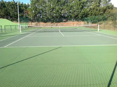 a tennis court with a net on top of it at Les chalets du Relais d'Aguilar in Tuchan