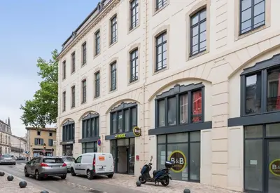 a building with a scooter parked in front of it at B&B HOTEL Castres Centre Gambetta in Castres