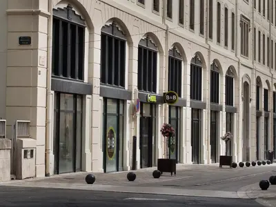 a large building with black windows on a city street at B&B HOTEL Castres Centre Gambetta in Castres