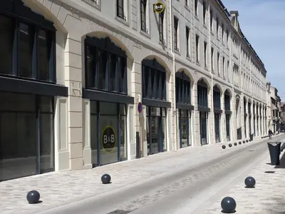 a large building with black balls on the street at B&B HOTEL Castres Centre Gambetta in Castres