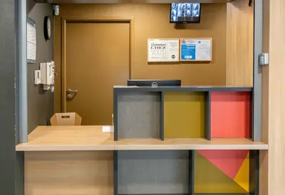 an office with a colorful counter and a door at B&B HOTEL Castres Centre Gambetta in Castres