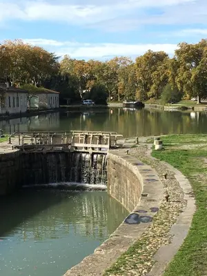 a small dam on a river in a park at Les Orchidées in Carcassonne