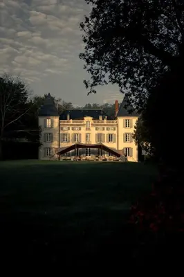 a large white house with a bridge in the yard at Château de la Bousquetarie in Lempaut