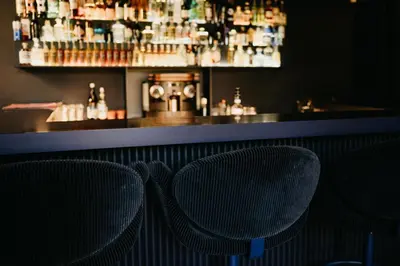 a bar with two chairs in front of a bar at Château de la Bousquetarie in Lempaut