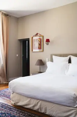 a bedroom with a large white bed and a window at Château de la Bousquetarie in Lempaut